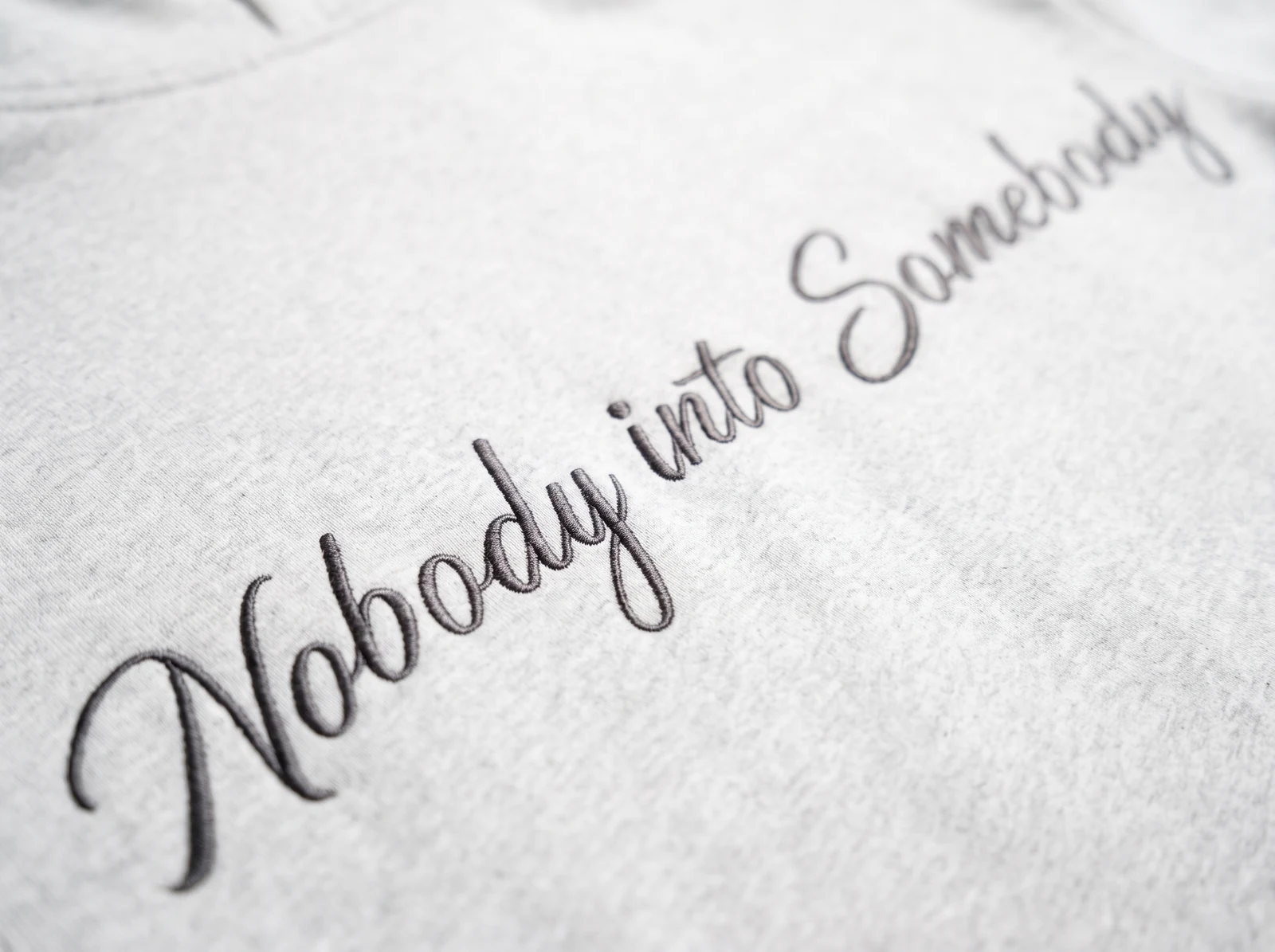 Nobody into Somebody embroidered in script across the back