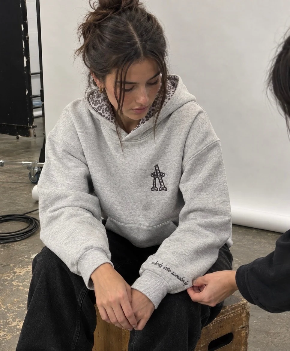 The hoodie worn, seated, behind the scenes at the shoot.